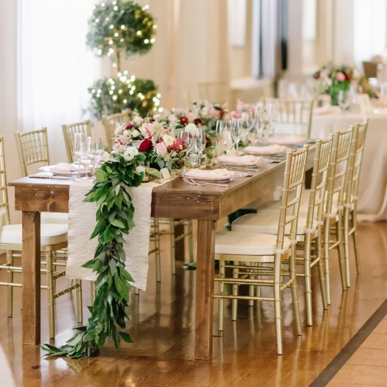Elegant table and chair rentals in Middlesex, NJ featuring gold Chiavari chairs and a rustic wood table styled for a wedding reception.